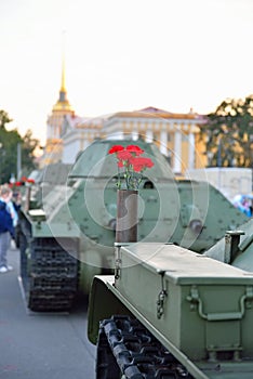 Red flowers in a gun cartridge on a medium Soviet tank T-34 on t