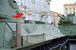 Red flowers in a gun cartridge on the middle of the Soviet tank