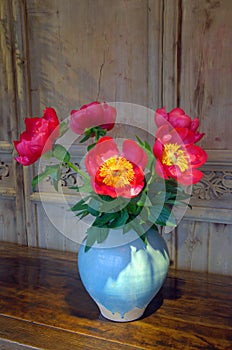 Red flowers in a vase on a wooded table