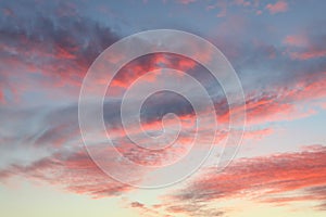 Red fluffy sunset clouds over blue sky