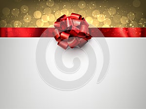 Red foil ribbon with beautiful bow on golden bokeh background