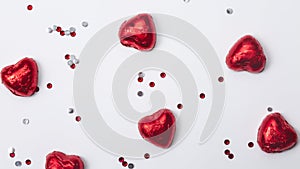 Red foiled chocolate hearts on a white background, chocolate hearts. Valentines day concept