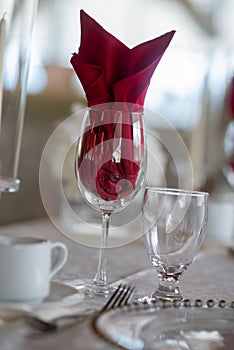 Red folded napkin in a wine glass, a table setting design idea