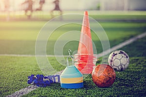 Red football and soccer training equipment on artificial turf.