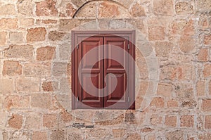 Red frame of one modern wooden window on yellow castle aged house