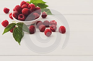 Red fresh raspberries on white rustic wood background