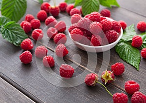 Red fresh raspberries on white rustic wood background