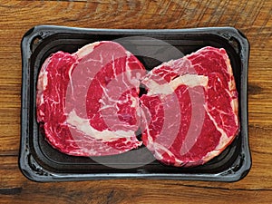 Red fresh rib eye steak on a plastic trey, premium beef.
