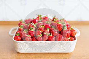 Red fresh strawberries from bio fields on a white dish in the kitchen