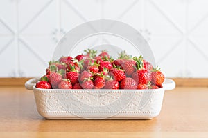 Red fresh strawberries from bio fields on a white dish in the kitchen