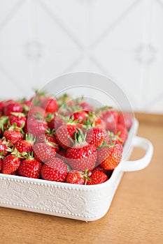 Red fresh strawberries from bio fields on a white dish in the kitchen