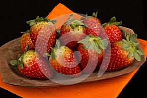 Red fresh strawberry in a bowl on black background