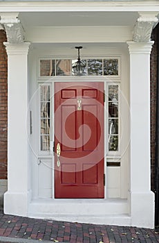 Red Front Door with White Door Frame and Windows on Brick Street