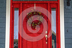 Red front door with wreath and glass panes in Utah