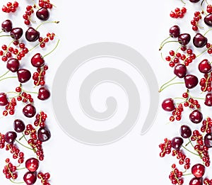 Red fruits and berrieson white background. Ripe red currants and cherries. Berries at border of image with copy space for text. Ba