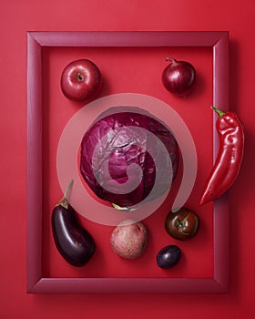 Red fruits and vegetables in wooden picture frame