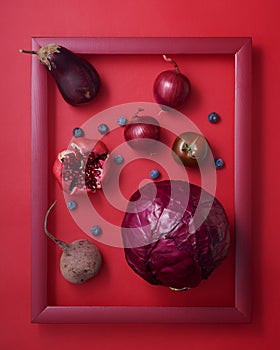 Red fruits and vegetables in wooden picture frame