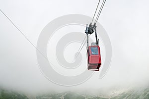 Červená lanovka nebo červená visutá lanovka na Lomnický štít v mlze nebo mracích, Vysoké Tatry, Slovensko