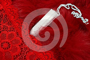 Red fur, red pants and a menstrual tampon. Vaginal products for intimate care. Woman critical days, gynecological menstruation cyc