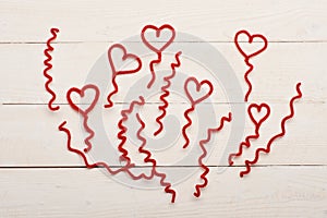 Red fuzzy wire hearts and ringlets on white vintage background