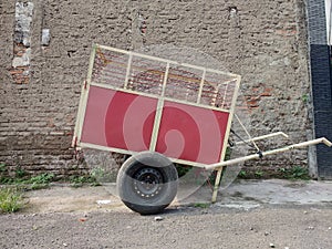 Red garbage cart on curb sidewall photo