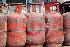 Red gas cylinders stand in a row on the street.