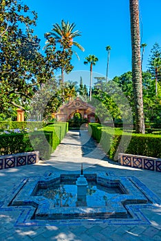 Red gate at gardens of Real Alcazar de Sevilla in Spain