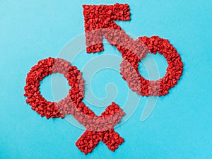 Red gender symbols of small hearts on a blue background. Male and female sign composed of hearts