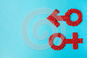 Red gender symbols of small hearts on a blue background. Male and female sign composed of hearts with copy space