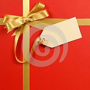 Red gift background, gold ribbon bow, blank gift tag or label, copy space, vertical