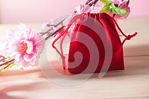 Red Gift Bag and plum blossom on Old Shabby Wooden Table concept Christmas and Newyear.