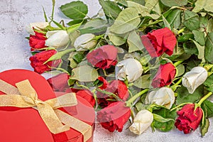 Red gift and a bouquet of roses, red and white. On a gray background. Congratulations to March 8 with Denm Birthday photo