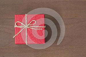 Red gift bow top view on wooden background with copy space.