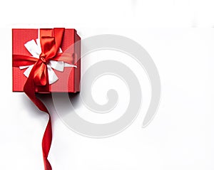 Red gift box with bow and ribbon on a white background, isolated image