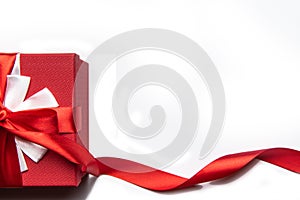 Red gift box with bow and ribbon on a white background, isolated image