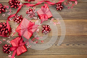 Red gift box with bows, on wooden background. Copy space. Valentine's day, birthday, Christmas