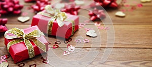 Red gift box with bows, on wooden background. Copy space. Valentine's day, birthday, Christmas baner