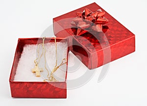 Red gift box with cross on chain within