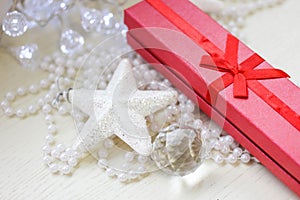 Red gift box, glittery white star and cristmas tree decorations