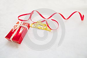 Red gift box and gold merry christmas text with red ribbon