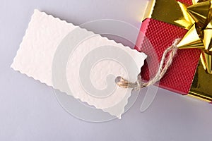 Red gift box with golden ribbon and label close up