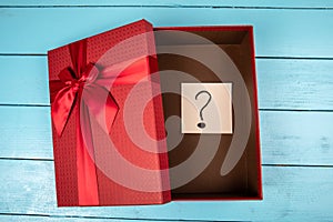 Red gift box with a question mark inside. Christmas, birthday or Valentine's Day concept