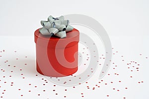 Red gift box or red present box with silver bow isolated on with glitter on white background. Christmas decoration