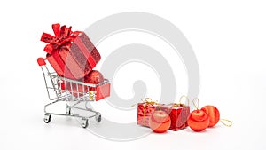 Red gift box in a shopping cart on a white background