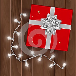 Red gift box, top view, gift box on wooden background with silver bow, vector illustration