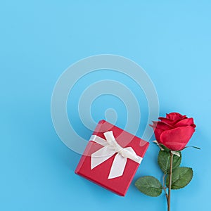 Red gift box with white ribbon bow and rose, concept of Valentine`s day, anniversary, mother`s day, birthday surprise present,