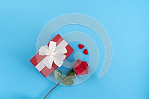 Red gift box with white ribbon bow and rose, concept of Valentine`s day, anniversary, mother`s day, birthday surprise present,