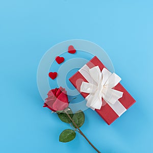 Red gift box with white ribbon bow and rose, concept of Valentine`s day, anniversary, mother`s day, birthday surprise present,