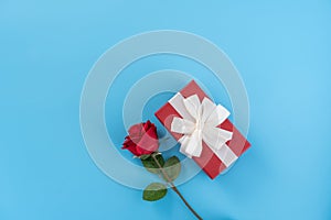 Red gift box with white ribbon bow and rose, concept of Valentine`s day, anniversary, mother`s day, birthday surprise present,