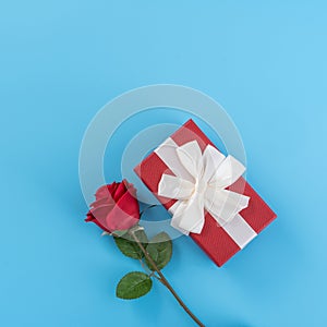 Red gift box with white ribbon bow and rose, concept of Valentine`s day, anniversary, mother`s day, birthday surprise present,